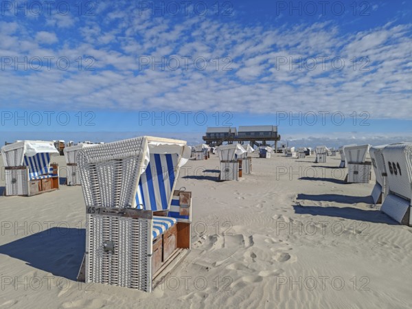 Preparing for the high season on the beach, setting up the beach chairs, North Sea, on the edge of the Wadden Sea National Park and UNESCO World Heritage Site, pile dwellings, sunshine and blue sky, SPO, Sankt Peter-Ording, Schleswig-Holstein, Germany