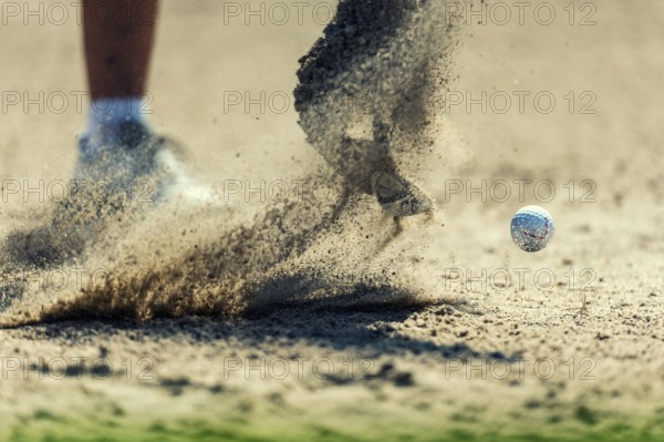 A golf ball is hit out of the bunker
