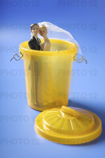 Wedding figurione on the yellow trash, divorce metaphor