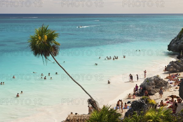 Tourists on the beach in front of the Mayan ruins of Tulum, Riviera Maya, Yucatan Peninsula, Caribbean, Mexico