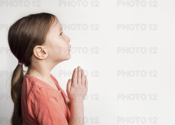 Beautiful little girl praying with copy space