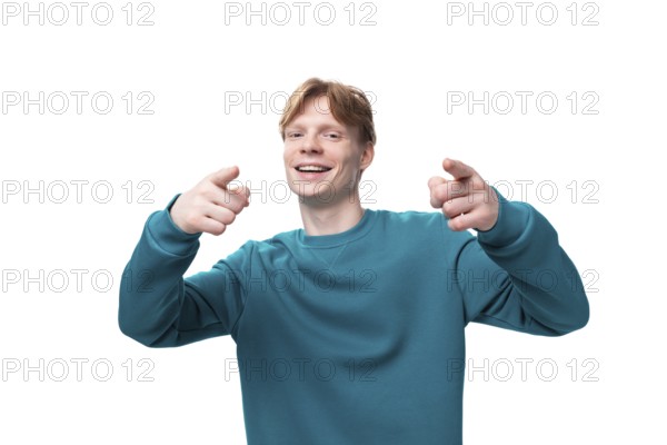Young positive man with red hair shows his hands on space for news