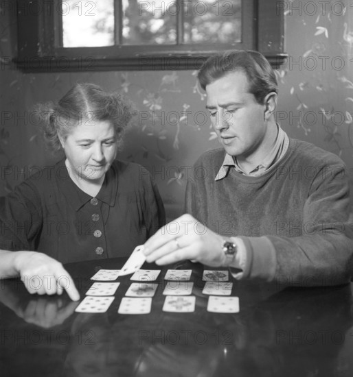 Playing solitaire in the 1940s. Swedish European boxing champion Olle Tandberg, 1918-1996. Pictured her with his mother playing solitaire. Sweden 1940s. Photo Kristoffersson Ref B140-1