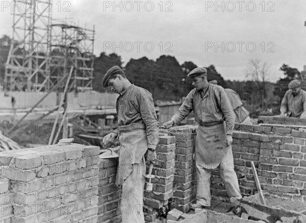 Builders in the 1940s. Two men are laying a brick wall. Sweden 1940s