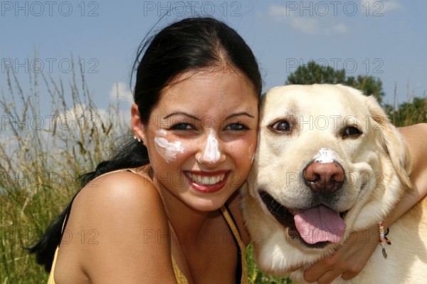 Woman and Labrador retriever with sun cream, sunscreen