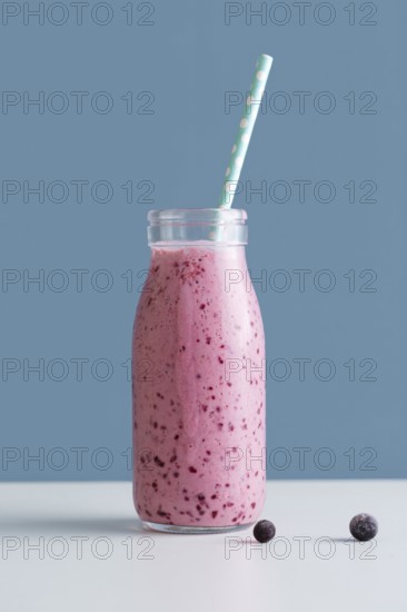 Front view pink smoothie bottle with straw blueberries