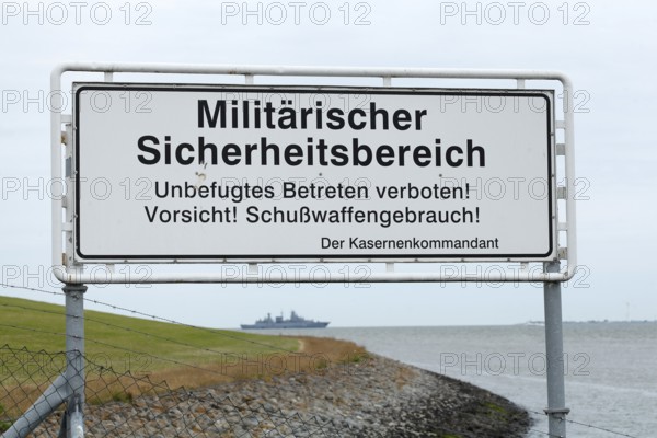 Warning sign with the inscription Militärischer Sicherheitsbereich, unbefugtes Betreten verboten, vorsicht Schußwaffengebrauch, Wilhelmshaven, Niedersachsen, Germany