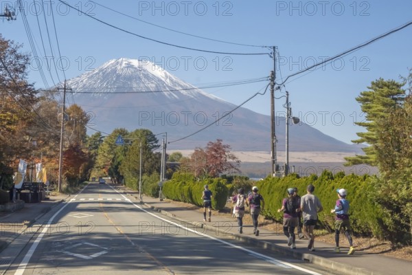 Yamanakako, Yamanashi Prefecture, Japan. Nov 5, 2023. Individuals engage in jogging against the Mount Fuji during the autumn season