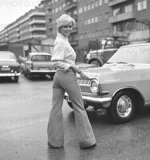 Fashion of the 1970s. A young woman wearing the typical fashion of the 1970s, wide legged trousers. A style called Bell-bottoms or flares, trousers that become wider from the knees and downward, forming a bell-like shape of the trouser leg. 1971. Kristoffersson ref EF65