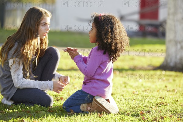 Kid girls playing in a park grass mixed ethnicity outdoors