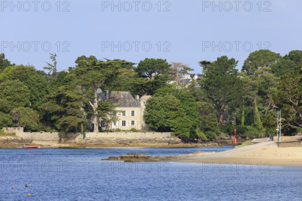 Coast of Combrit, district Le Moguer with historic villa by the sea, seen from Benodet, department Finistere Penn ar Bed, region Bretagne Breizh, France