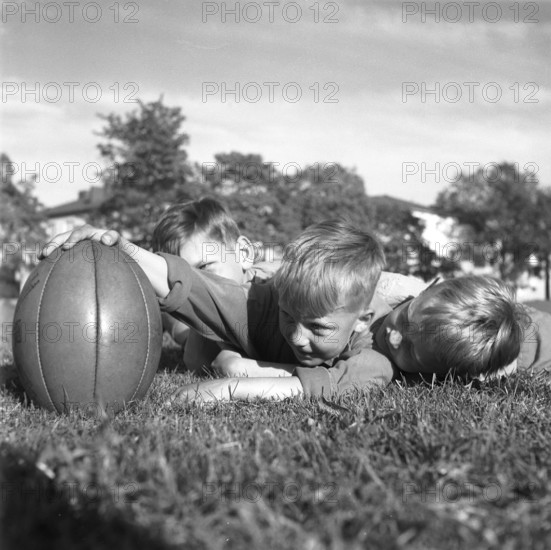 Rugby 1940. Three young rugby players lying in the grass on the rugby field, one holding the rugby ball. The rugby ball has an oval shape, four panels and a weight of about 400 grams. 1942. Kristoffersson ref A56-5