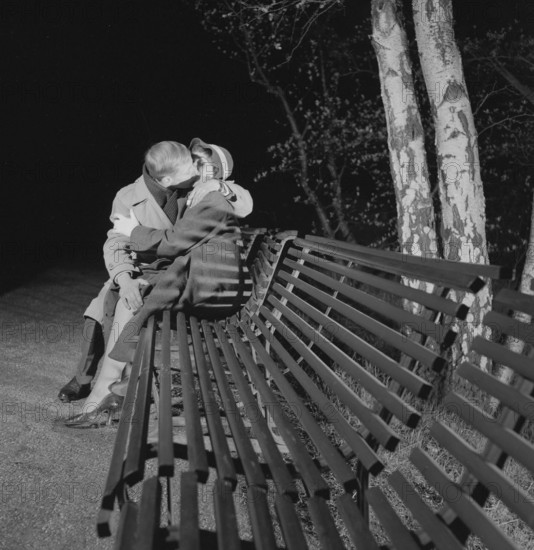 In the 1950s. A young couple is sitting on a bench kissing. A date ending pretty well. Sweden 1953 Conard ref 2402