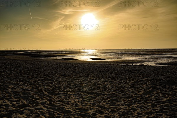 Golden sunset creates a warm atmosphere on a sandy beach, North Sea beach 27476 Cuxhaven/Sahlenburg-Germany