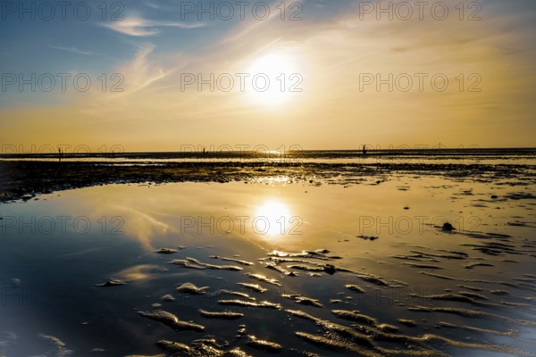 Sunset with clear reflection in the calm water on a sandy beach, North Sea beach 27476 Cuxhaven/Sahlenburg-Germany