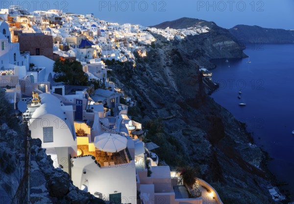 Blue hour after sunset, view from Oia to white buildings on the crater rim, Santorini, Cyclades, Greece