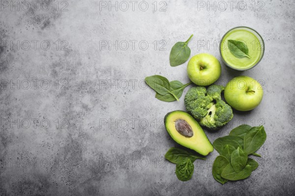Ingredients for making green healthy smoothie with broccoli, apples, avocado, spinach, stone background. Clean eating, detox plan, diet, weight loss concept. Close up, top view, space for text