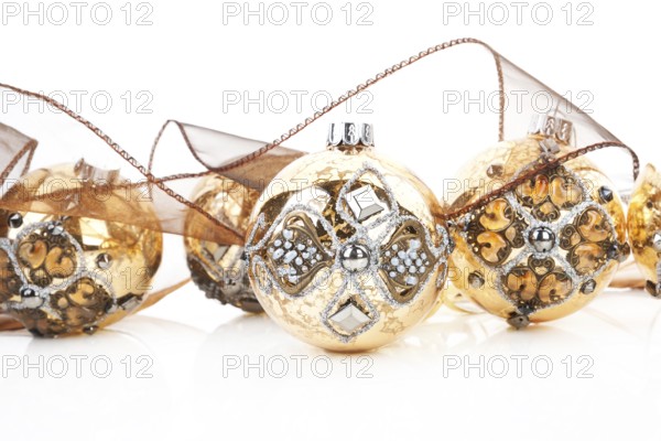 Luxurious antique golden christmas balls decorated with brown ribbon. Traditional festive xmas background