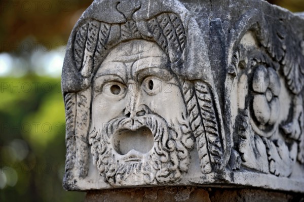 Ancient stone sculpture, stone carving of a mask, Roman theatre, ancient port city of Rome, excavation site Archaeological Park Ostia Antica, metropolitan city of Rome, Lazio, Italy