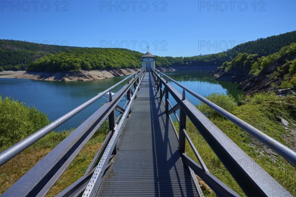 Metal footbridge over a large water reservoir, surrounded by green landscape, summer, Urft dam wall, Obersee, Urftsee, Schleiden, Eifel National Park, Eifel, North Rhine-Westphalia, Germany