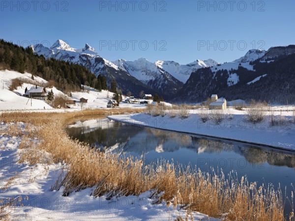 River Sihl flows into Lake Sihl, reservoir, behind the snow-covered mountains Flübrig and Druesberg, Euthal, Canton Schwyz, Switzerland
