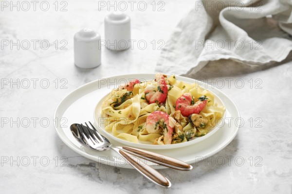A plate of fettuccine allo scoglio showcases a mix of seafood, including shrimp and mussels, perched on tender pasta