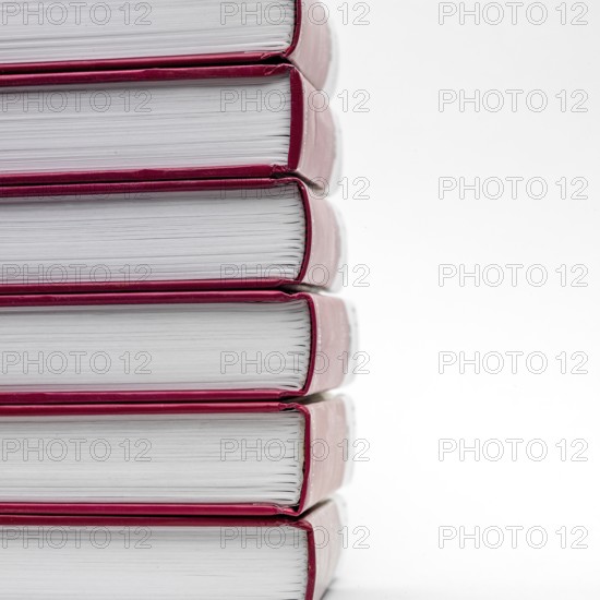 Stacked books with red spines creating a minimalist display against a white background
