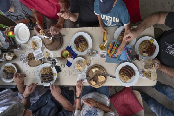 Food in a pub in Middle Franconia, Franconian Obazda, dressed cheese, sausages with sauerkraut and bread, child painting at the table, Middle Franconia, Bavaria, Germany Snack in Franconia, served with bread in a pub, Franconia, Bavaria, Germany