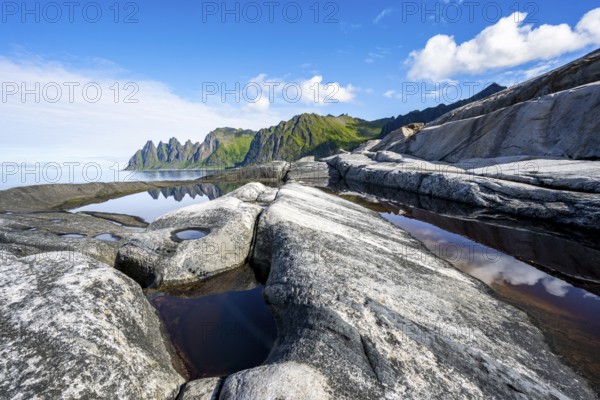 Reflection in a tidal pool, rocky coast of Tungeneset, Devil's Teeth, Okshornan, Ersfjorden, Senja Island, Troms, Norway