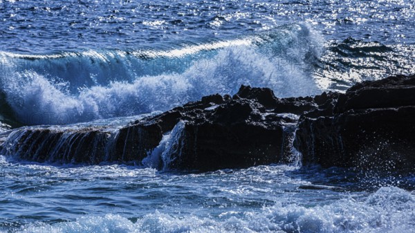Rugged rocky coastline and foaming spray, on Stecci beach, near Capoliveri, Elba Island, Tuscan Archipelago National Park, Tuscany, Italy