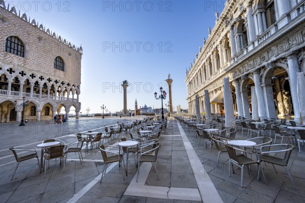 Chairs and tables of cafes at Piazetta San Marco, Doge's Palace and Colonna di San Marco and Colonna di San Todaro, in the morning light, St Mark's Square, Venice, Veneto, Italy