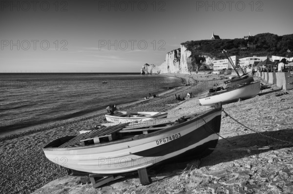Rowing boat, boats lying on the beach, pebble beach, rock arch Falaise or Porte d'Amont, church Chapelle Notre Dame de la Garde, Étretat, sea, steep coast, cliffs, chalk cliffs, alabaster coast, La Côte d'Albâtre, black and white, Normandy, Seine-Maritime, France