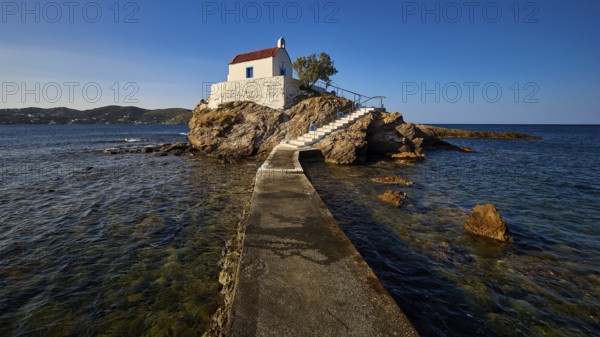 A pier leads to a white church on a rock, surrounded by the blue sea, chapel, church, Agios Isidoros, rocky islet, Bay of Gourna, Kokkali, Leros, Dodecanese, Greek Islands, Greece