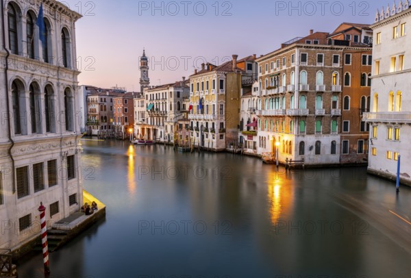 View of the Grand Canal at sunset, picturesque evening mood with illuminated palazzos on the canal and the church tower of the Chiesa Parrocchiale dei Santi Apostoli, long exposure, view from the Rialto Bridge, Venice, Veneto, Italy