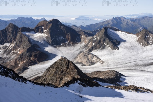 At the summit of Wilder Freiger, picturesque high mountain landscape with snow, view of Übeltalferner glacier and rocky mountain peaks Königshofspitz and Sonklarspitze, Stubai Alps, South Tyrol, Italy