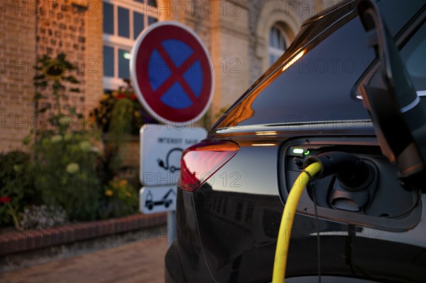 Charging station for electric cars, electric charging station, e-charging station, e-mobility, charging cable leads into Audi 45 e-tron electric car, traffic sign, absolute stopping ban, Étretat, Normandy, Seine-Maritime, France