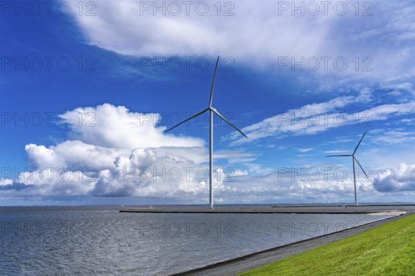 Strekdammen Wind Farm, wind farm at the seaport of Eemshaven in the Netherlands, built on offshore breakwaters, 2 GE Cypress 5, 5 MW turbines, with 158 metre blade diameter, together produce 11 MW of power, can supply 15, 500 households with electricity from wind, cumulus cloud over the North Sea, Netherlands