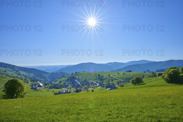 Sunny panoramic view of a village surrounded by green hills under a clear sky, spring, Schauinsland, Hofsgrund, Freiburg im Breisgau, Black Forest, Baden-Württemberg, Germany