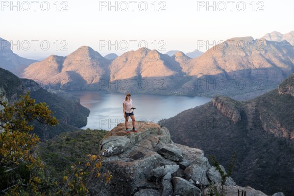 Hiker enjoying sunset at Blyde River Canyon, view of canyon with Blyde River in the evening light, canyon landscape, Panorama Route, Mpumalanga, South Africa