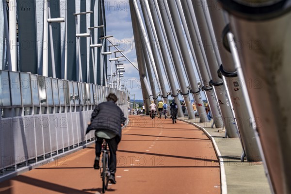 Cycle and pedestrian bridge Snelbinder Brug, over the river Waal near Nijmegen, was added to the existing railway bridge, fast cycle path connection from the city centre of Nijmegen and the new housing estates in the Waalsprong district, Netherlands