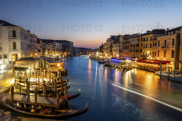 View of the Grand Canal at the blue hour, picturesque evening mood with illuminated palazzos on the canal, long exposure, view from the Rialto Bridge, Venice, Veneto, Italy