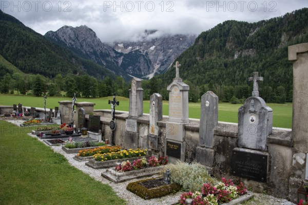 Graves and flowers at a cemetery in front of a mountain landscape, Zgornje Jezersko, Gorenjska, Slovenia