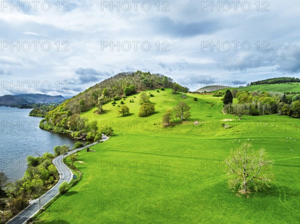 Farms and mountains over Ullswater Lake from drone, Pooley Bridge, Lake District National Park, Cumbria, England, United Kingdom