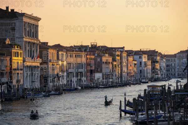 View of the Grand Canal with gondoliers at sunset, picturesque evening mood with palazzos on the canal, view from the Rialto Bridge, Venice, Veneto, Italy