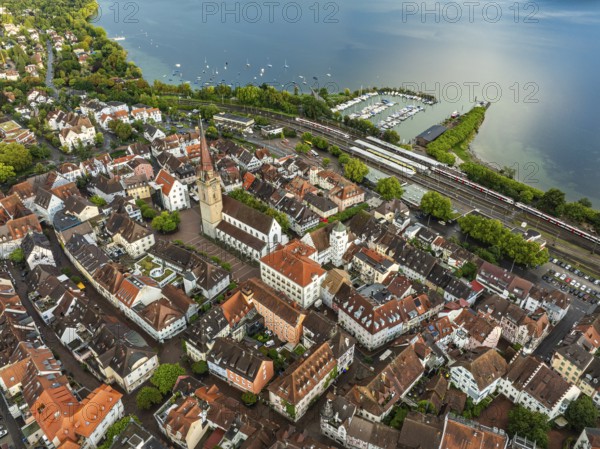 Luftbild von der Stadt Radolfzell am Bodensee mit der historischen Altstadt, dem Radolfzeller Münster und den Jachthafen nach einem Gewitterschauer von der Abendsonne angestrahlt, am Horizont ein Regenbogen, Landkreis Konstanz, Baden-Württemberg, Deutschland
