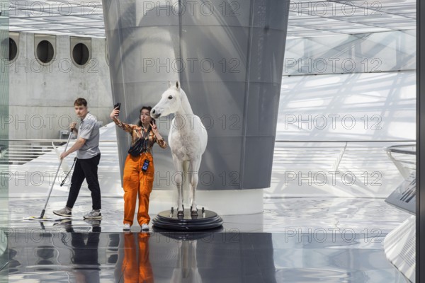 The Mercedes-Benz Museum in Stuttgart presents a journey through the automotive history of the global corporation. The history of the Mercedes star begins with the first automobile in 1886. 160 vehicles are on display. Entrance area with exhibited horse. Stuttgart, Baden-Württemberg, Germany