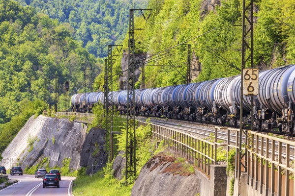 Goods train travelling on the winding Geislinger Steige railway line. Landscape along the railway line in spring. Amstetten, Baden-Württemberg, Germany