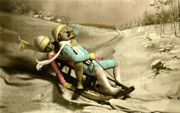 Two children sledding, 1930s, Two children in colourful winter clothing sledding in a snowy landscape, Historical photo