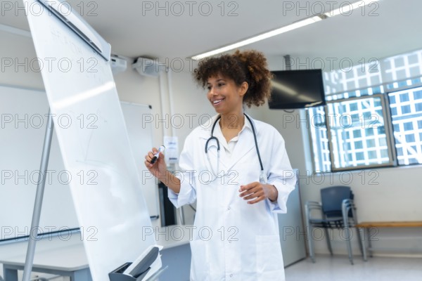 Female medical professional explaining a concept drawing on a whiteboard during a medical lecture in a hospital conference room