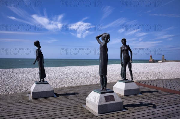 Bronze sculpture La Heure du Bain by Dominique Denry on the beach, sky, blue, behind it beacon Feu de la jetée Sud, lighthouse, red, Phare de Fécamp, green, harbour entrance, Fécamp, Normandy, Seine-Maritime, France